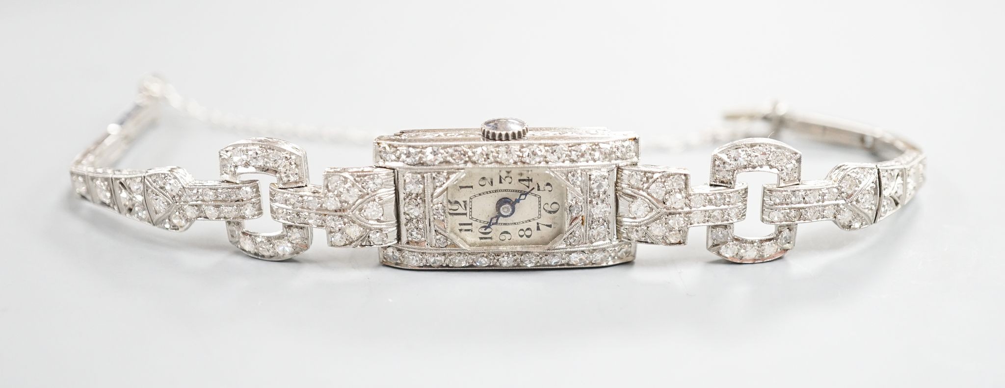 A lady's white metal (stamped platinum) and diamond set cocktail watch, the bracelet with diamond set shoulders, approx. 16cm, gross weight 23.8 grams.